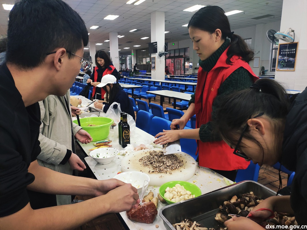 食堂里,志愿者们正在处理包饺子的食材。.jpg 食堂里,志愿者们正在处理包饺子的食材。.jpg